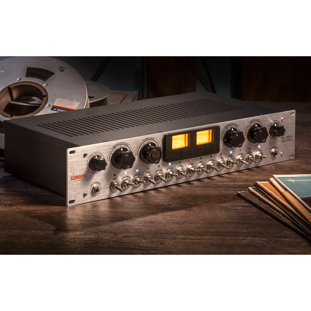 Warm Audio WA-2MPX microphone preamp with controls and input/output jacks, shown on a professional audio setup.