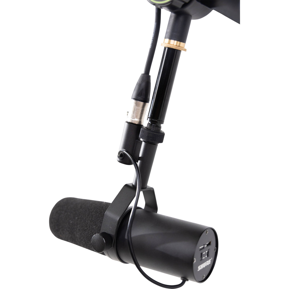 Shure SH-BROADCAST1 broadcast microphone arm mounted on a desk, adjustable metal arm with cable management for professional audio setup.