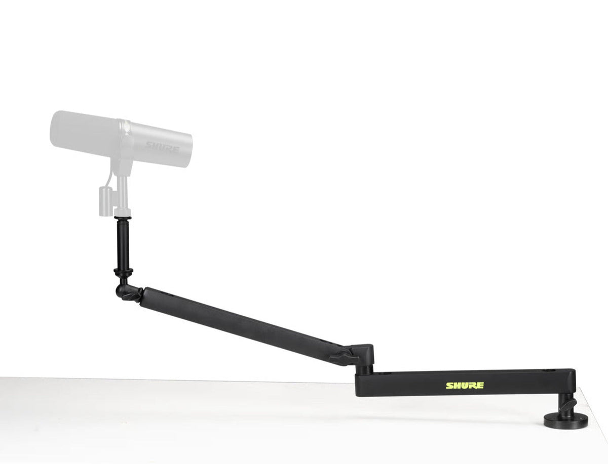 Shure SH-BROADCAST2 broadcast microphone arm mounted on a desk, adjustable arm for professional podcast or studio microphone setup.