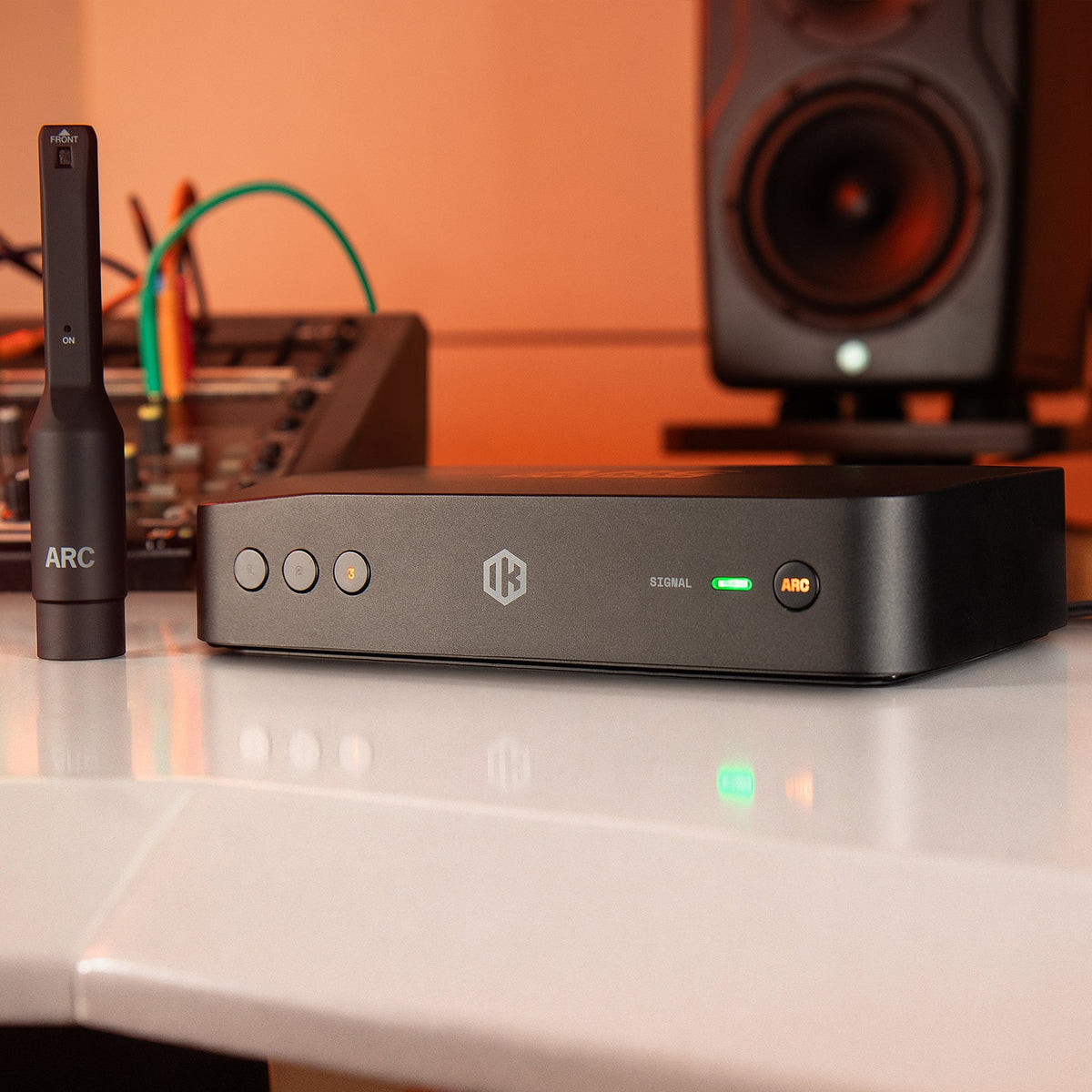 IK Multimedia ARC Studio+, with ARC microphone next to studio monitor